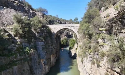 Antalya&rsquo;da 20 metre y&uuml;kseklikteki tarihi k&ouml;pr&uuml;den suya atlayan gen&ccedil; y&uuml;rekleri ağza getirdi
