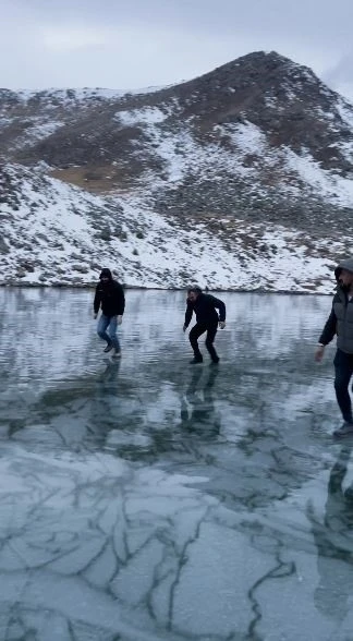 Artvinli gençler buz tutan Karagöl’de taş atıp test ettiler, sonra eğlendiler
