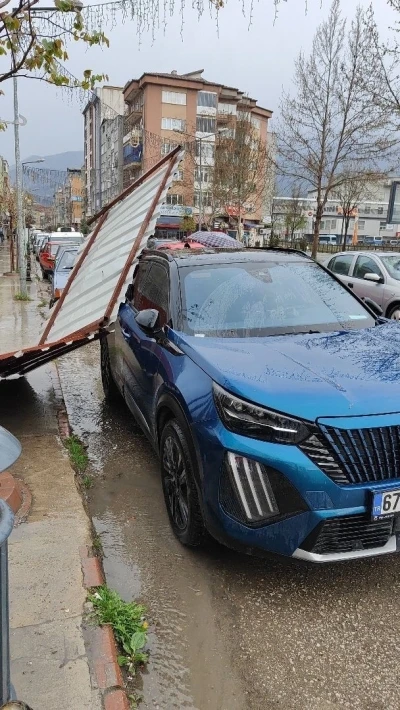 Fırtınanın etkisiyle yapıdan kopan par&ccedil;a araca zarar verdi
