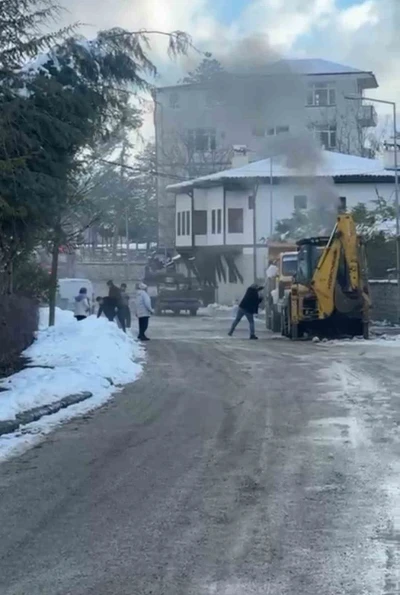 İş makinesinde &ccedil;ıkan yangını karla s&ouml;nd&uuml;rmeye &ccedil;alıştılar
