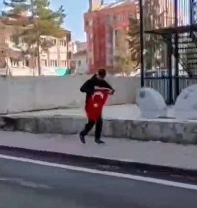 Kaldırımda g&ouml;rd&uuml;ğ&uuml; T&uuml;rk Bayrağı&rsquo;nı koşarak alan &ccedil;ocuk, kask kamerasıyla g&ouml;r&uuml;nt&uuml;lendi
