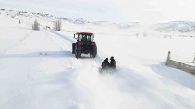 Kar yağışını fırsata &ccedil;evirdiler, trakt&ouml;r&uuml;n arkasında kayarak eğlendiler
