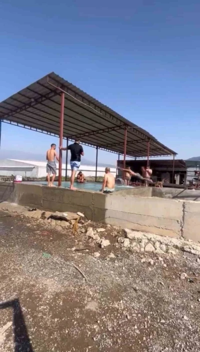 Kavurucu sıcaktan bunalan tarım işçileri maydanoz havuzunda serinledi
