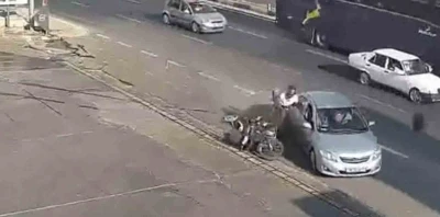 Kazada motosiklet sürücüsü çarpıştığı otomobilin kapısına tutunup sonra yere düştü
