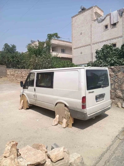 Mardin’de minibüs sürücüsü, aracın tekerlerini sıcaktan korumak için kartonla kapattı
