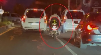 Motosiklet s&uuml;r&uuml;c&uuml;s&uuml; trafikte kaskı başına takması yerine arkasına bağladı

