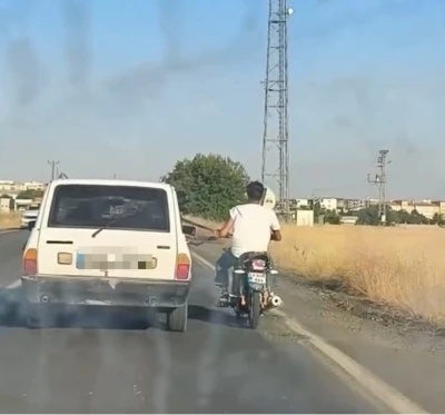 Otoyolda tehlikeli yolculuk: Motosiklet, otomobil kemerine tutunarak ilerledi
