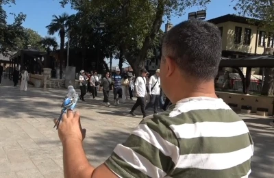 Sahibinin omzunda ve elinde çarşıyı geziyor
