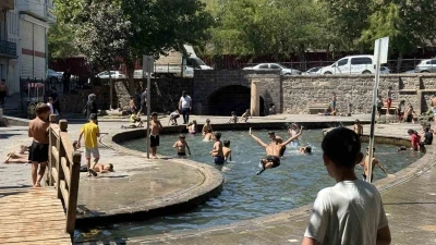 Sıcak havada kavrulan çocuklar, süs havuzunda serinliyor
