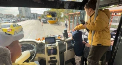 Şoför minibüse binen yolcularına meyve ve şekerleme ikram ediyor
