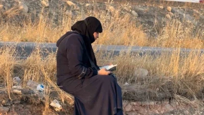 Ters dönen araçtan çıkan kadın oturup Kuran’ı Kerim okudu
