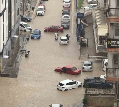Yağmurda mahsur kalan motosikletli &ccedil;areyi otomobilin &uuml;zerine &ccedil;ıkmakta buldu
