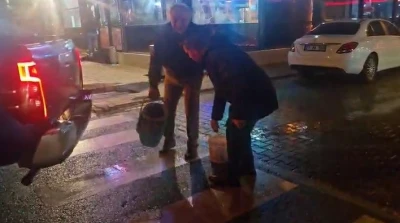 Yolda oluşan çukurları görünce dayanamayan esnaf  kum ve çakılla çukurları kendisi kapattı
