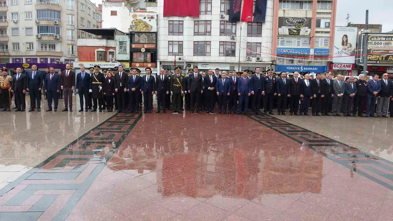 Kilis Cumhuriyet Meydanı’nda yağmur altında düzenlenen törende askerlerle birlikte saygı duruşunda duran çocuklar