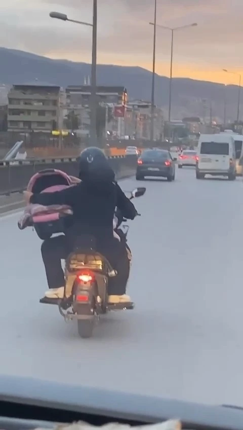 Motosiklet üzerinde bebeği pusetiyle taşıdı
