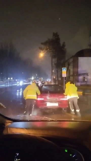 Arızalanan otomobili trafik polisleri yağmurun altında itti
